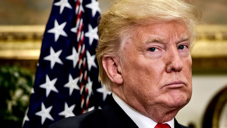 Donald Trump in a publicity shot with the American flag behind him.jpg